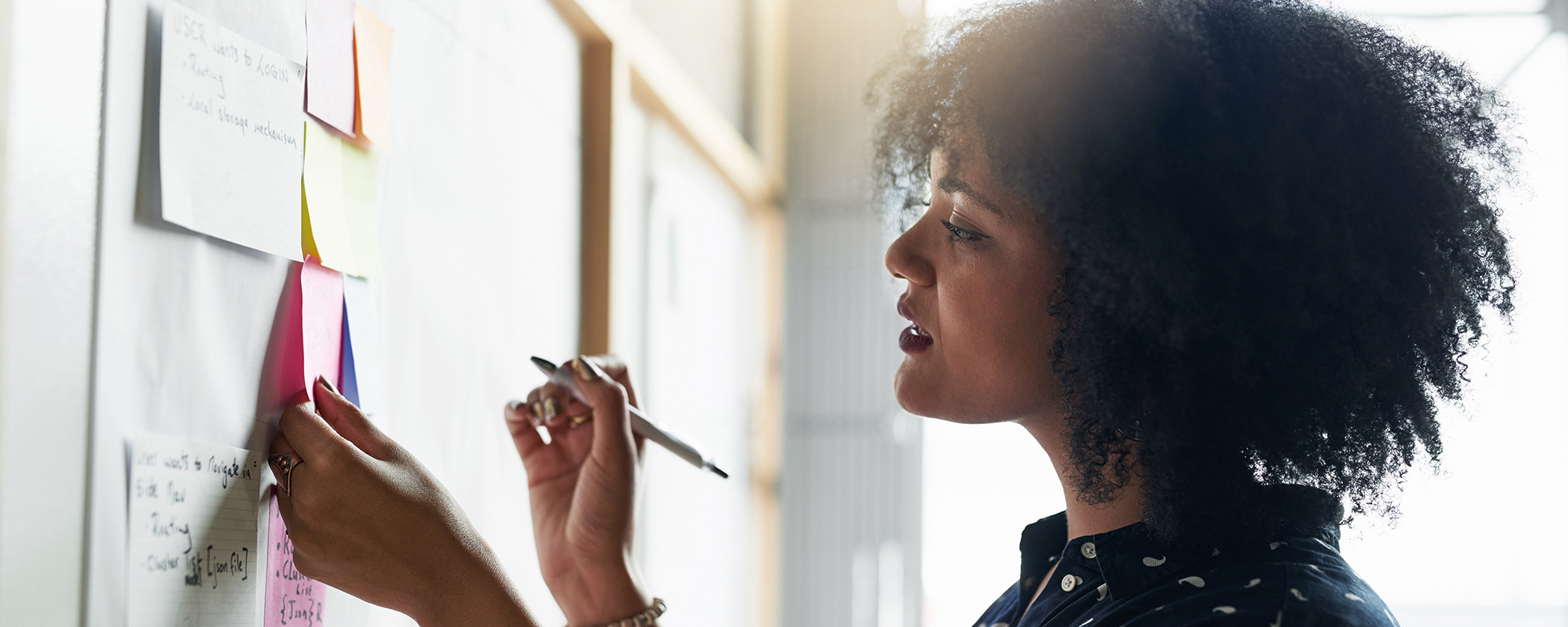 A woman wiring on sticky notes