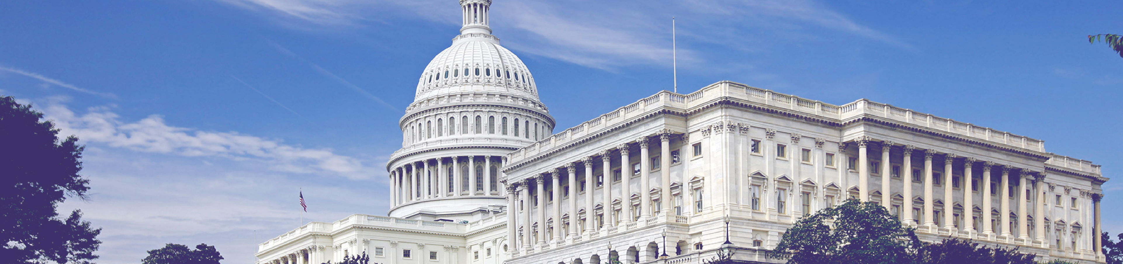 Two women smiling and looking at a child